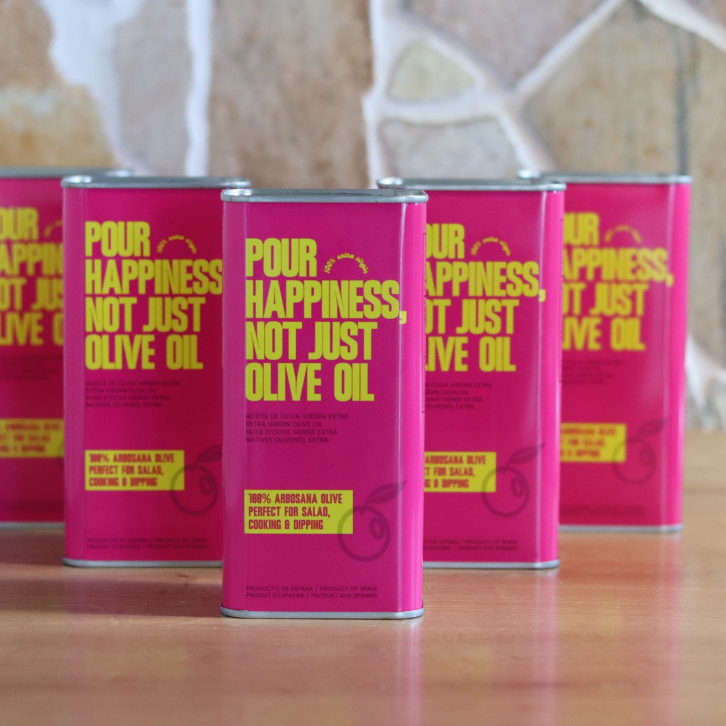 Six bottles of POUR HAPPINESS Family The Daily Drizzle olive oil in dark glass bottles with pouring spouts.